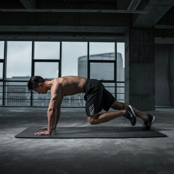 Focused man doing a core strengthening exercise on a mat.
